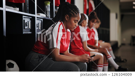 Sports, texting and woman with smartphone, locker room and communication on social media and online. Gym, soccer player and person with mobile for chat, typing and girl with sportswear for match 126104009