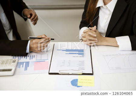 Businessman holding a pen and talking to businesswoman Businessman holding a pen and talking to businesswoman 126104065