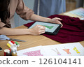 designer is using electronic  pencil for Clothing design 126104141