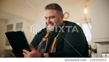Tablet, man and chef in kitchen for online recipe planning, instructions or research for cook book. Happy, digital technology and male person reading culinary review on restaurant business in home. 126104201