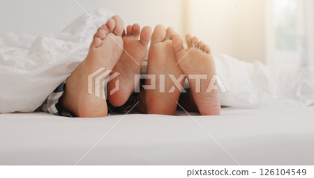 People, feet and relax in bed with love, lazy weekend and romantic getaway in hotel. Couple, toes and sleeping in resort bedroom with touch, comfort or relationship development with trust in marriage 126104549