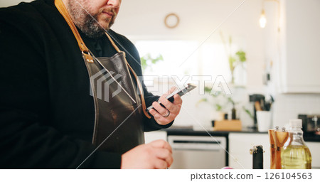 Hands, smartphone and man in kitchen, cooking and message to contact, online recipe and instructions. Dinner, person and chef with cellphone, home and digital app for ingredients or website for food 126104563