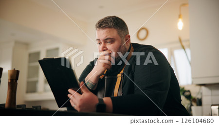 Tablet, stress and chef in kitchen for online recipe planning, instructions or research for cook book. Shock, digital technology and male person reading negative culinary review on restaurant in home Tablet, stress and chef in kitchen for online recipe planning, instructions or research for cook book. Shock, digital technology and male person reading negative culinary review on restaurant in home 126104680