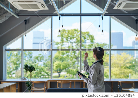 A woman inspecting an air conditioning unit 126104884