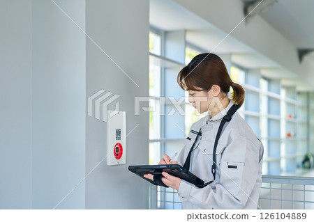 一名婦女檢查緊急警報設備 一名婦女檢查緊急警報設備 126104889