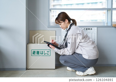 一名婦女正在檢查疏散梯 一名婦女正在檢查疏散梯 126104891