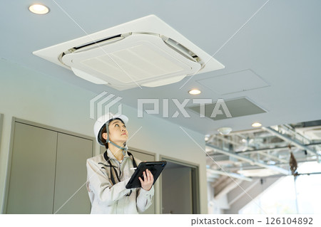 一名女士正在檢查空調機組 126104892