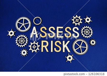 Assess Risk alphabet letters with gears element on navy blue background 126106318