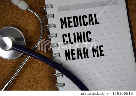 Medical Clinic Near Me text on paper with stethoscope flat lay on cork board background 126106619