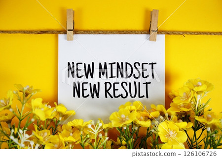 New Mindset New Result text on paper card with flower blooming decoration on yellow background 126106726