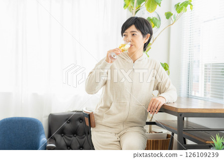 Woman drinking champagne in the room 126109239