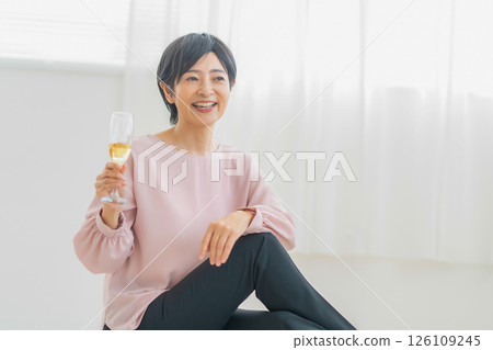 Woman drinking champagne in the room Woman drinking champagne in the room 126109245