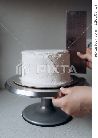 Measuring Cake Height with Metal Ruler for Precision 126109415