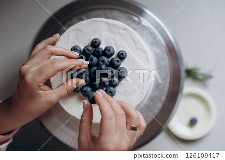 Decorating Cake with Fresh Blueberries by Hand Decorating Cake with Fresh Blueberries by Hand 126109417