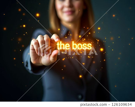 Confident businesswoman showcasing leadership qualities with the words the boss illuminated in her hand 126109634