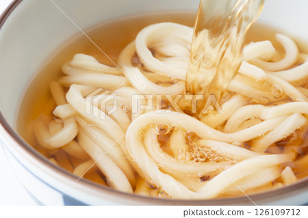 湯汁傾瀉在美味烏龍面上的特寫鏡頭 湯汁傾瀉在美味烏龍面上的特寫鏡頭 126109712