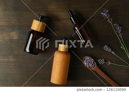 Lavender oil in bottles with lavender flowers on a dark background Lavender oil in bottles with lavender flowers on a dark background 126110090