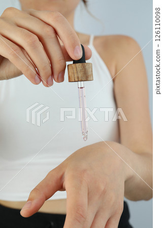 A dropper with lavender oil in a woman's hand A dropper with lavender oil in a woman's hand 126110098