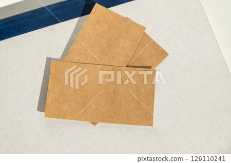Brown kraft paper cards on white background with blue accent 126110241