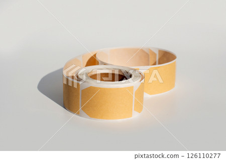 Roll of blank rectangular adhesive labels on plain background 126110277