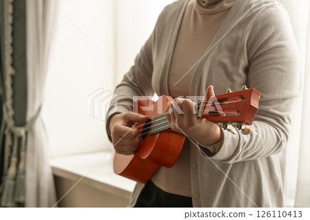 窗邊彈奏夏威夷四弦琴的老年婦女 126110413