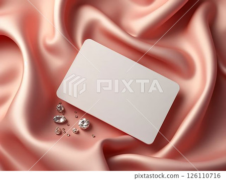 Elegant blank card on soft pink satin with sparkling gems in a sophisticated setting for creative presentations or invitations 126110716