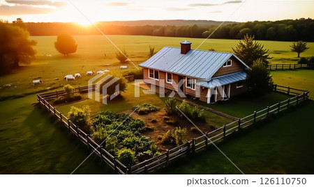 Serene sunset over a rustic farmhouse amidst lush greenery and grazing sheep in a tranquil countryside setting 126110750
