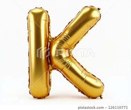 Golden balloon letter K stands against a plain background showcasing its shiny surface and three-dimensional shape 126110771