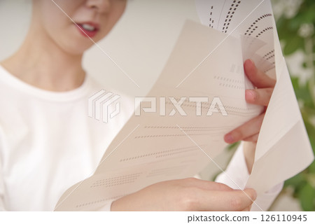 Asian woman looking at documents Asian woman looking at documents 126110945