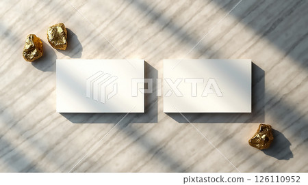 Elegant display of blank business cards beside golden stones on a marble surface in soft natural light Elegant display of blank business cards beside golden stones on a marble surface in soft natural light 126110952