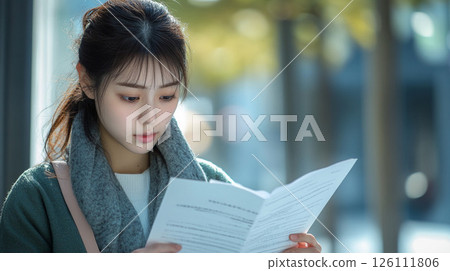 Woman reading a document Woman reading a document 126111806