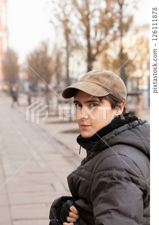 young man walking in European quiet city street with trees. lifestyle waist up portrait. tourism, date 126111878