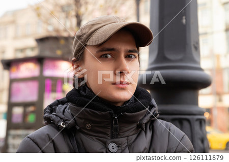handsome serious 22 year old male student wearing cap on city street. lifestyle portrait. tourism, date handsome serious 22 year old male student wearing cap on city street. lifestyle portrait. tourism, date 126111879