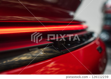 Rear view of a red 2025 Porsche 911 GT3 922, featuring an illuminated LED taillight, glossy paint, and detailed rear grille in an indoor setting. Rear view of a red 2025 Porsche 911 GT3 922, featuring an illuminated LED taillight, glossy paint, and detailed rear grille in an indoor setting. 126112239