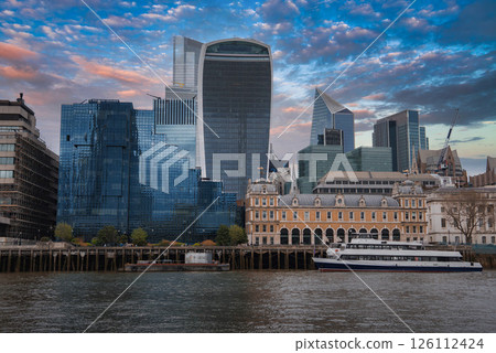 View of London's skyline featuring the Walkie Talkie and Scalpel buildings, the River Thames, a docked boat, and a historic building in the foreground. View of London's skyline featuring the Walkie Talkie and Scalpel buildings, the River Thames, a docked boat, and a historic building in the foreground. 126112424