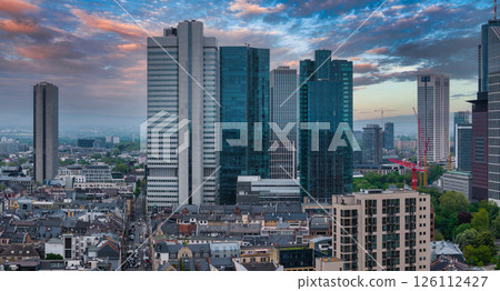 Aerial view of Frankfurt, Germany, showcasing the skyline with Eurotower, modern skyscrapers, traditional architecture, and a vibrant sunset sky. Aerial view of Frankfurt, Germany, showcasing the skyline with Eurotower, modern skyscrapers, traditional architecture, and a vibrant sunset sky. 126112427