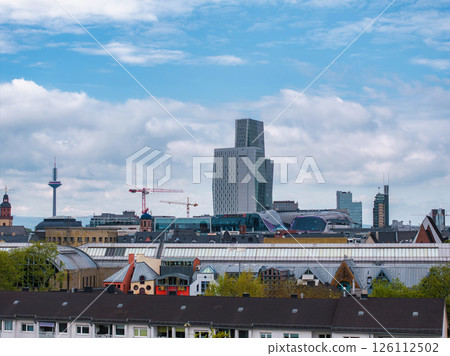 Frankfurt cityscape with Westend Tower and Europaturm, showcasing modern and traditional architecture, residential rooftops, and construction cranes. Frankfurt cityscape with Westend Tower and Europaturm, showcasing modern and traditional architecture, residential rooftops, and construction cranes. 126112502