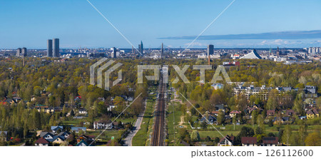 Riga, Latvia, featuring a railway through a residential area, the National Library, Riga TV Tower, Ferris wheel, and a mix of modern and historic buildings. Riga, Latvia, featuring a railway through a residential area, the National Library, Riga TV Tower, Ferris wheel, and a mix of modern and historic buildings. 126112600