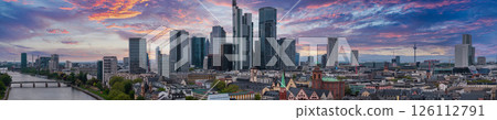 Aerial view of Frankfurt, Germany, featuring the skyline with Commerzbank Tower, Main Tower, River Main, bridges, and Frankfurt Cathedral at sunset. 126112791