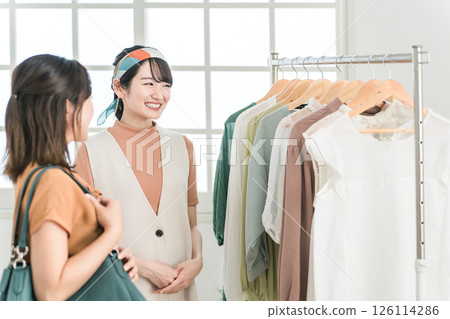 A customer woman (shopping) who talks with a clerk at a fashion/clothing/apparel shop A customer woman (shopping) who talks with a clerk at a fashion/clothing/apparel shop 126114286