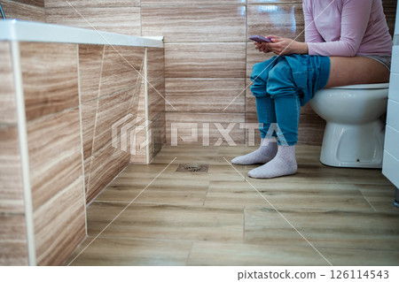 Relaxing moment on the toilet with phone in quiet bathroom Relaxing moment on the toilet with phone in quiet bathroom 126114543