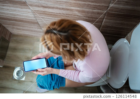 Relaxing moment while engrossed in smartphone activity indoors 126114548