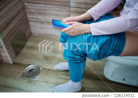 Relaxing moment on the toilet while scrolling through a smartphone Relaxing moment on the toilet while scrolling through a smartphone 126114551