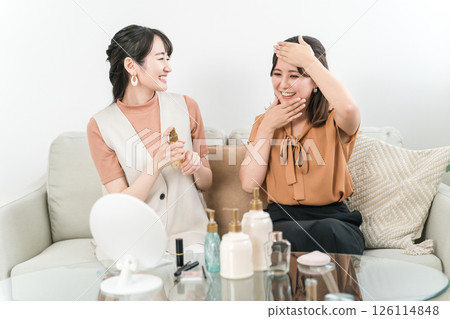 Asian woman recommending cosmetics to friends (lotion, skin care) 126114848