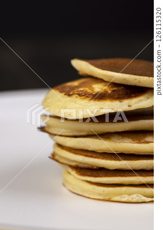 pancakes stacked together on a bowl, a tower of small milk pancakes on a bowl pancakes stacked together on a bowl, a tower of small milk pancakes on a bowl 126115320