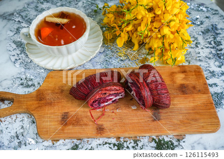 Spring tea party with yellow flowers, bow-shaped dessert and black tea on grey background 126115493