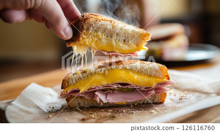 Hot Cuban sandwich being pulled apart with melted cheese strings and steam, showing layers of ham, pickles, and mustard in a warm bistro setting with golden light Hot Cuban sandwich being pulled apart with melted cheese strings and steam, showing layers of ham, pickles, and mustard in a warm bistro setting with golden light 126116760