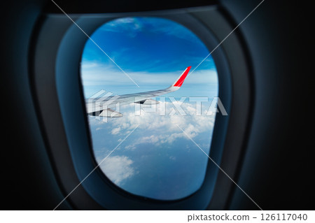 View from airplane window and airplane wing clouds and sky Air travel and tourism View from airplane window and airplane wing clouds and sky Air travel and tourism 126117040