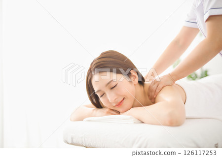 Young woman receiving a massage at an esthetic salon Young woman receiving a massage at an esthetic salon 126117253