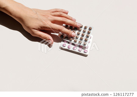 Woman Hand Selecting Contraception Pill Blister Pack. Medical Concept for Reproductive Health and Family Planning. Woman Hand Selecting Contraception Pill Blister Pack. Medical Concept for Reproductive Health and Family Planning. 126117277